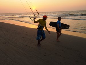 Zwei Kitesurfer am Strand bei Sonnenuntergang