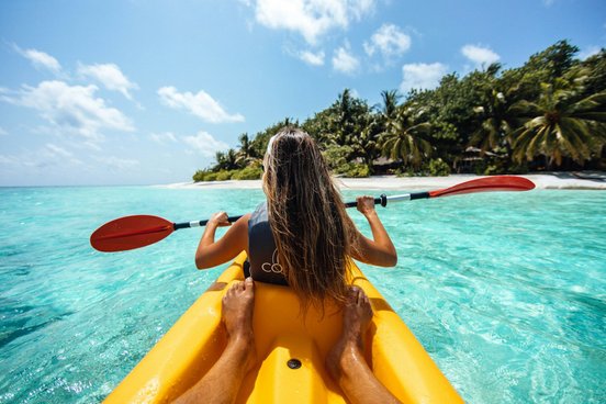 Zwei Menschen im einem gelben Kayak in türkisfarbenen Wasser