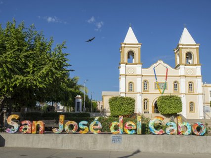 ??????????????????????????????????????????????????????????????????? Exterior of Mission San Jose del Cabo with bird flying in sky above