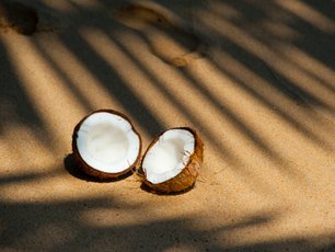Aufgeschnittene Kokusnuss am Strand