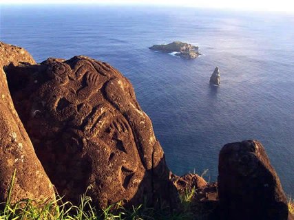 Osterinsel - Fels mit eingravierten Mustern im Vordergrund und zwei Felsen im Meer im Hintergrund
