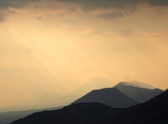 Sonnenuntergang bei regnerischem Wetter über den Bergen