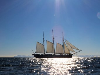 Sonnen scheint auf das Segelschiff mit offenen Segeln