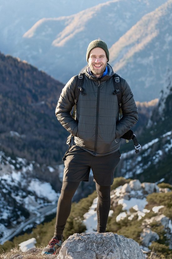 Rieseleiter Madeira Reisen, Man steht auf Bergspitze in Winterjacke und Mütze