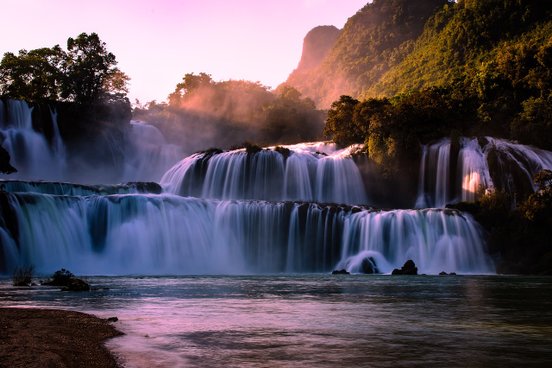Wasserfall im Sonnenuntergang leuchtet lila, rosa