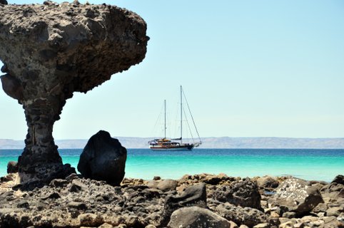 Baja California Rundreise - Fels und Blick auf das Meer und ein Boot