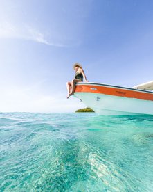 Frau auf Boot in türkisblauem Wasser - Belize