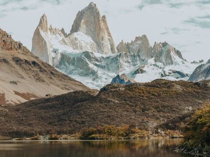 Patagonien Rundreise Selbstfahrer - Fitz Roy - Schneebedeckte Bergspitzen über bewaldetem Hügel und ruhigem See im Vordergrund