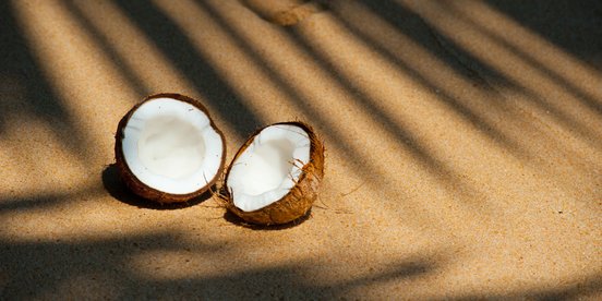 Aufgeschnittene Kokusnuss am Strand