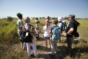 Reisegruppe steht in der Natur und lauscht den Worten des Reiseleiters