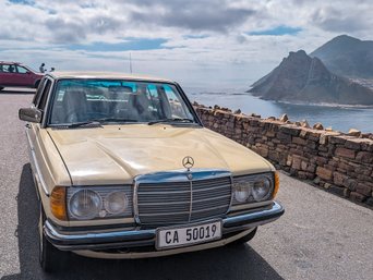 Mercedes steht am Straßenrand vor Meer