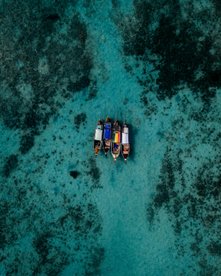 Blick von oben auf mehrere Boote auf dem türkisblauen Meer