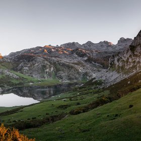Bergsee spiegelt umgebende Gipfel im Morgenlicht