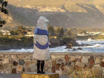Eine Schaffigur blickt aufs Meer
