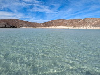 Glasklares flaches Wasser eines sehr breiten Strandes