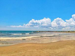 Gelber Sand, blaues Wasser und strahlender Himmel