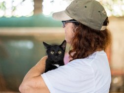 Frau mit einer Straßenkatze auf dem Arm