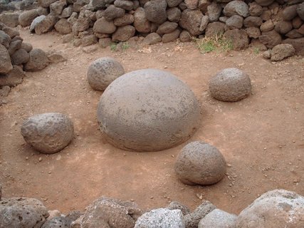 Osterinsel - Steinmauer aus unregelmäßig geformten Steinen mit sandigem Boden und großen runden Steinen im Vordergrund