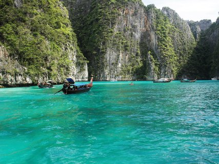 Südthailand entdecken - Boot im Meer vor Steilküste