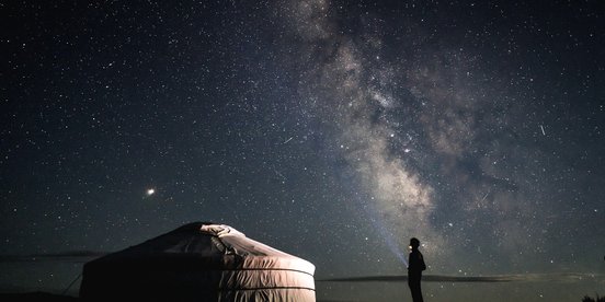 Mann steht nachts vor Jute - Mongolei rundreise