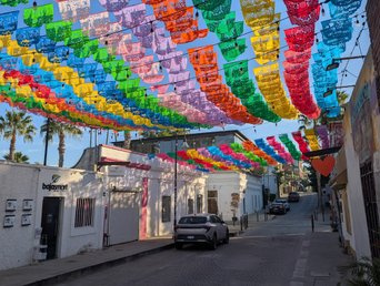 Bunte Fahnen zieren den blauen Himmel einer Straße der Altstadt San Joses in Baja California