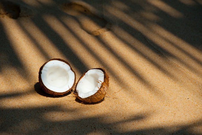 Aufgeschnittene Kokusnuss am Strand