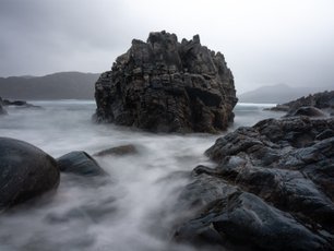 Langzeitbelichtung von Felsen im Meer in schwarz-weiß