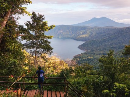 ?????????????????????????????????????????????????????????????????????????????????????????????????????????????????????????????????????????????????????? young woman on a wooden bridge appreciating a beautiful view of the Mombacho volcano and the Apoyo lagoo