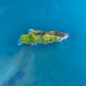 Kleine grüne Insel im blauen Meer