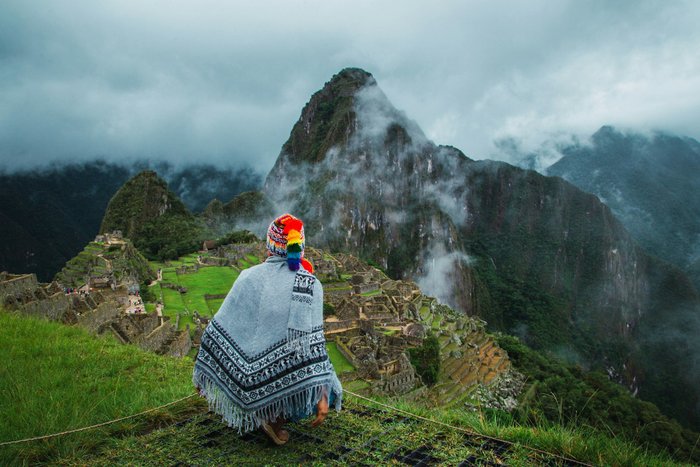 Mensch mit peruanischem Poncho vor Machu Picchu - Beste Reisezeit Peru