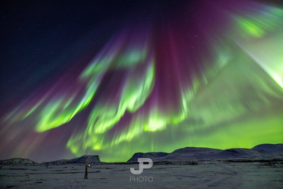 Bunte Nordlichter über verschneiter Landschaft