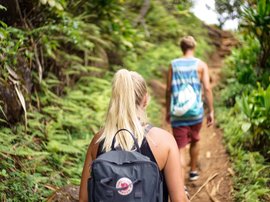 Zwei Menschen laufen im Dschungel für ein Trekking