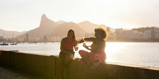 Zwei Frauen trinken bei Sonnenuntergang in Rio de Janeiro