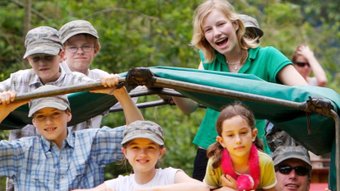 Fröhliche Kinder auf Tour in einem offenen Jeep