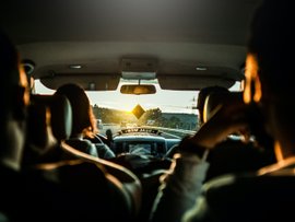 Menschen in einem Fahrzeug bei Sonnenuntergang
