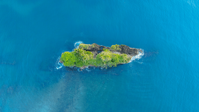 Kleine grüne Insel im blauen Meer