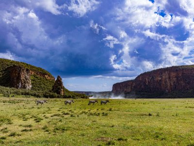 Zerkluftete Berglandschaft mit Wiese und Zebras - Kenia Highlights