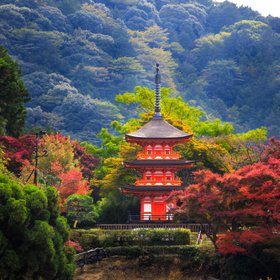 Ein roter Tempelturm inmitten herbstlicher Landschaft