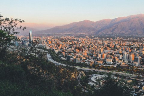 Patagonien Rundreise Selbstfahrer - Santiago - Blick auf eine Stadt mit Hochhäusern und Bergen im Hintergrund bei Sonnenuntergang