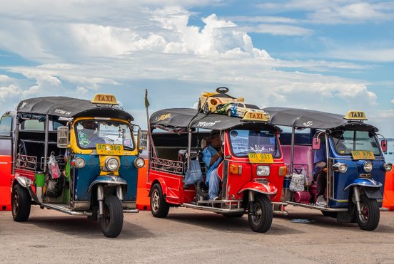 Drei farbenfrohe Tuktuks parken nebeneinander