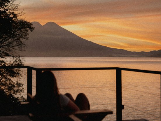 Frau bewundert den Sonnenuntergang am Atitlan See