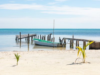 weißer Strand mit blauem Boot - Belize Highlights