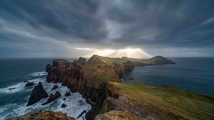 Raue Küste in Madeira mit einem dunklen, wolkenverhangenen Himmel