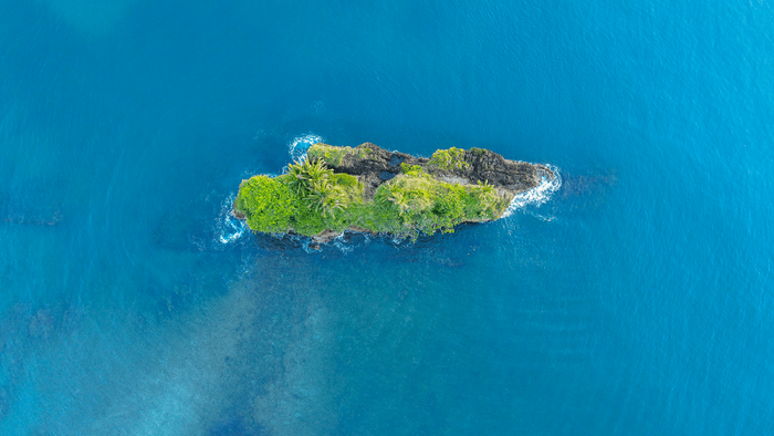 Kleine grüne Insel im blauen Meer