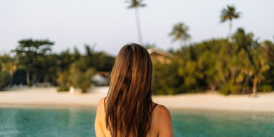 Frau im Bikini am Strand, Hintergrund verschwommen