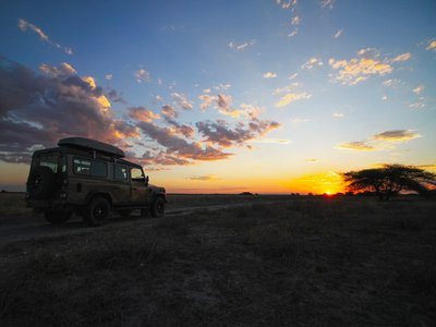 Jeep im Sonnenuntergang afrikanische Savanne - Botswana Highlights