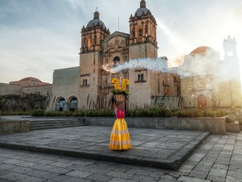 Bei mystischer Stimmung steht eine Frau vor einer alten Kirch in Mexiko