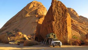 Auto vor einem Felsen in Namibia