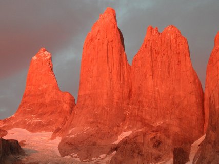 Patagonien Rundreise Selbstfahrer - Torres del Paine - Drei markante, steil aufragende Felsnadeln vor bewölktem Himmel