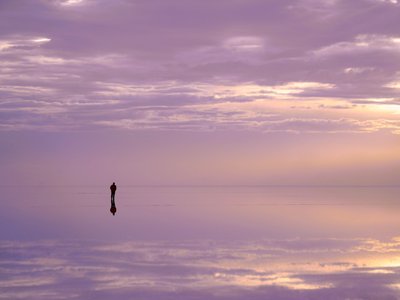 Mensch reflektiert in Wasser der Salar de Uyuni - Peru und Bolivien Highlights